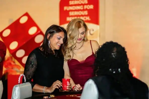 Two women smiling at a charity event for childhood cancer awareness.