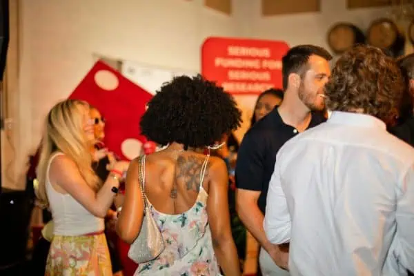 People socializing at a CURE Childhood Cancer fundraising event.