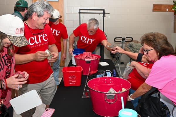 People donating money at CURE Childhood Cancer event in Bryan County.