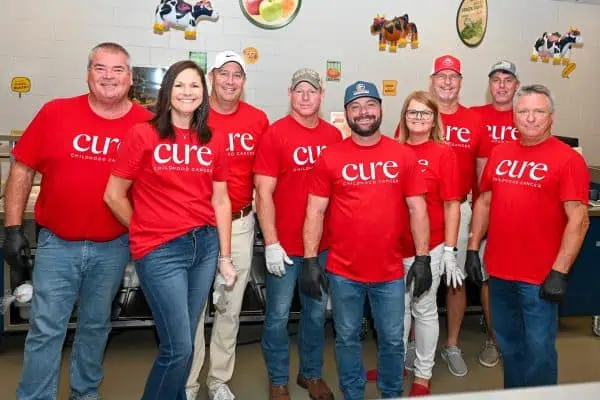 Group of volunteers in red CURE shirts at Catie's Gathering event.