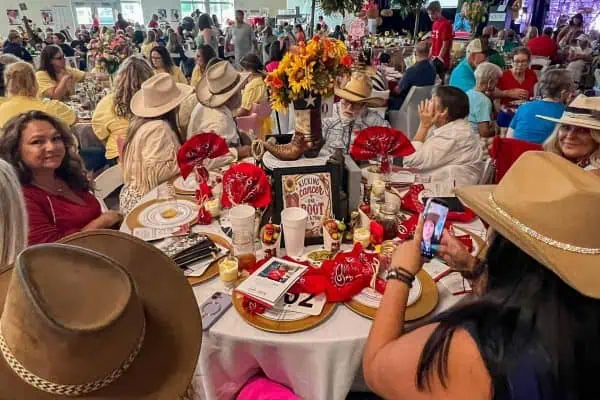 People wearing cowboy hats at a charity event for childhood cancer awareness.