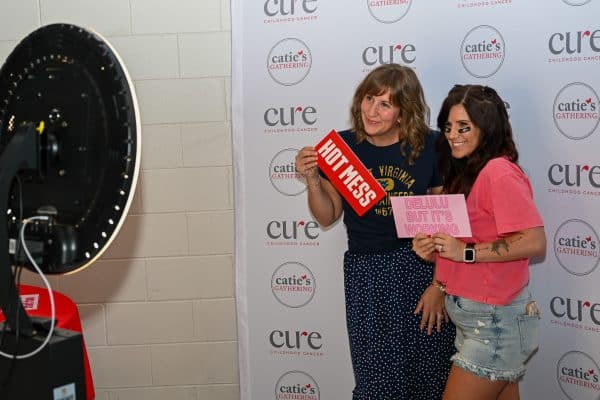 Two women taking a fun photo at CURE Childhood Cancer event.