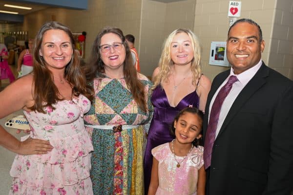 Group of smiling adults and a child at CURE Childhood Cancer event.