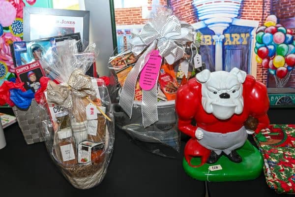 Gift display with toys and a Santa-themed bulldog figurine for CURE Childhood Cancer.