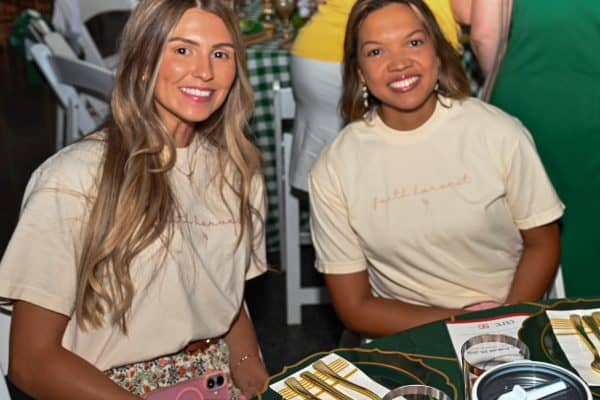 Two women smiling at CURE Childhood Cancer gathering event.