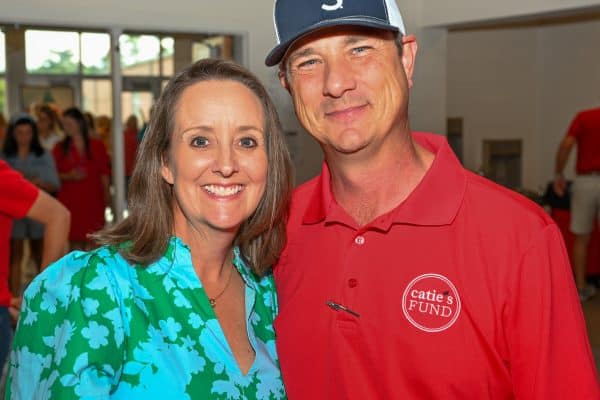 Smiling woman and man at Catie's Fund event for childhood cancer awareness.