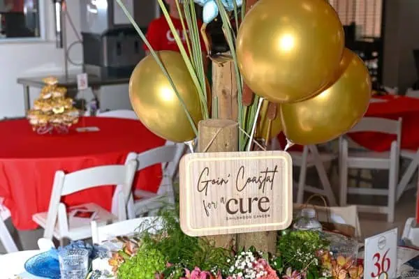 Colorful centerpiece with stork, balloons, and flowers for CURE event.