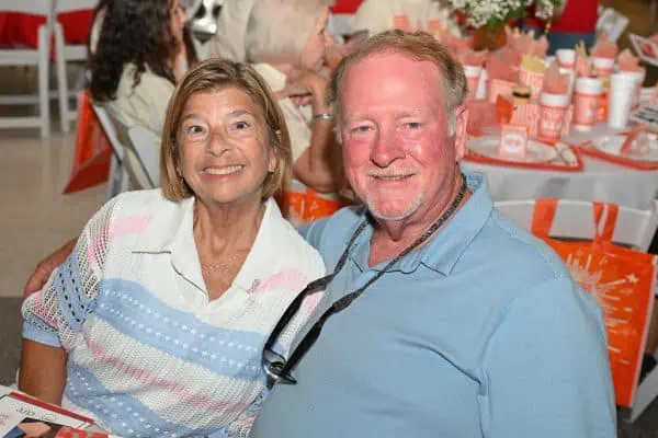 Smiling woman and man at CURE Childhood Cancer gathering.