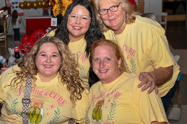 Group of women at CURE Childhood Cancer event wearing yellow shirts.